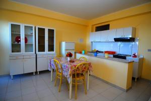 特罗佩阿Appartamenti Del Sole的厨房配有桌椅和冰箱。