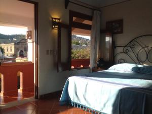 瓦哈卡市Hotel Maela的一间卧室设有一张床和一个美景窗户。