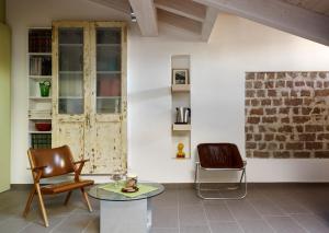 雷焦艾米利亚B&B Sottotetto的客厅配有两把椅子和一张桌子