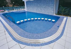 甘迪亚RH里维埃拉酒店 - 仅限成人 的游泳池铺有蓝色和白色瓷砖地板。