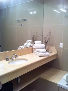 埃斯特角城Departamento Green Park的浴室配有盥洗盆、镜子和毛巾