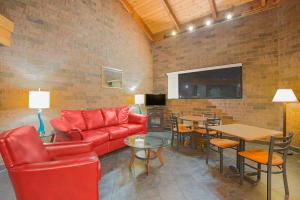 威洛比Skylight Inn Willoughby - Cleveland Mentor的客厅配有红色的沙发和桌子