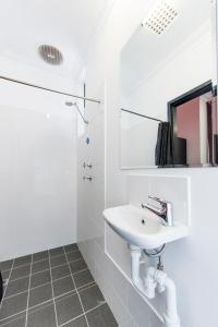 珀斯分流背包客度假旅舍的白色的浴室设有水槽和淋浴。