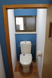 白马村白马羚羊木屋的一间带白色卫生间的浴室和窗户。