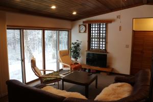 白马村白马羚羊木屋的客厅配有沙发和桌子