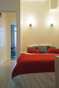 巴黎圣赫尔蒙巴克公寓的一间卧室配有一张带红色枕头的大床