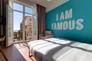 塞萨洛尼基Colors Urban Hotel Thessaloniki的一间卧室设有一张蓝色墙壁的大床