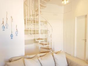 切里亚莱La Casa Bianca的带沙发和螺旋楼梯的客厅