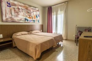 巴拉格尔Hostal Sant Miquel的一间卧室设有一张床和一个大窗户