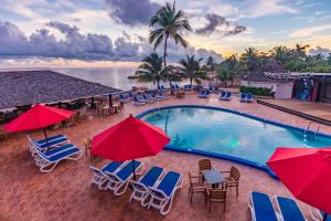 拉纳韦贝Decameron Club Caribbean Runaway Bay, Ramada All-Inclusive Resort的一张带椅子和遮阳伞的度假村游泳池的图片