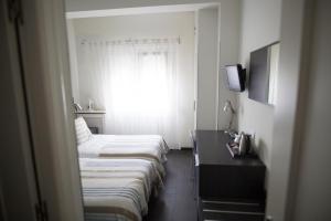 桑坦德卡宝马约尔旅馆的酒店客房设有三张床和窗户。