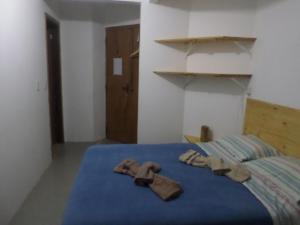 Sentinela do SulHostel Ibirakati Inn的床上的2双拖鞋