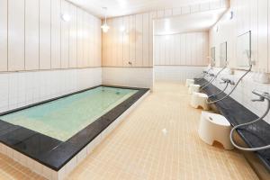 御殿场市富士山御殿场市精选旅馆的一间带热水浴缸、水槽和卫生间的浴室