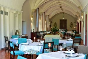 贝雅修道院贝雅佩斯塔纳酒店&度假村的用餐室配有白色的桌子和蓝色的椅子