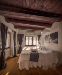 特伦托特伦托戈利斯科尔西住宿加早餐旅馆的卧室配有带窗帘的大型白色床