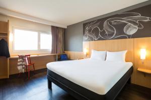 波尔多波尔多拉克宜必思酒店的卧室配有一张白色大床和一张书桌