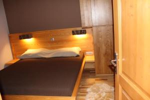 霍茨科波霍尔耶Apartment Appohorje的一间小卧室,配有一张带木制床头板的床
