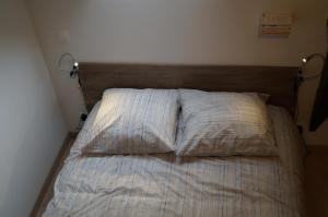 康卡勒L'atelier的卧室内配有一张未铺床,提供两个枕头