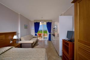 利卡斯戴勒圣莫妮卡度假村的一间卧室配有一张床、一张沙发和一台电视