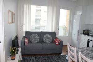 奥卢Apartment Nallisuites的客厅配有灰色的沙发和桌子