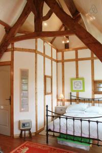 CourtilsGite du courtils的一间带一张床的卧室,位于带木制天花板的房间内