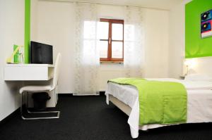 弗里德贝格布鲁诺酒店的一间卧室配有绿色和白色的床以及电视。