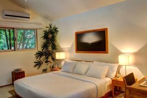 诺萨拉Moana Surf Resort的卧室配有一张床,墙上配有电视。