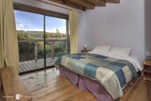弗鲁蒂亚尔Antuquelen Lodge Cabañas的一间卧室设有一张床和一个大窗户