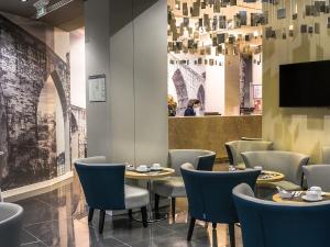 里斯本里斯本圣本托酒店的一间带桌椅和电视的餐厅