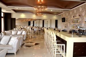 马尔马里埃维亚套房酒店的餐厅内的酒吧配有白色椅子和吧台