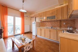 尼亚普拉莫斯Peramos Apartments的厨房配有木制橱柜和白色冰箱。