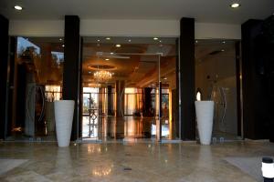 马尔马里埃维亚套房酒店的大堂的地板上摆放着三只白色花瓶