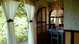 安齐拉贝Eco Lodge Les Chambres Du Voyageur的一间设有门的房间和一个带窗帘的窗户