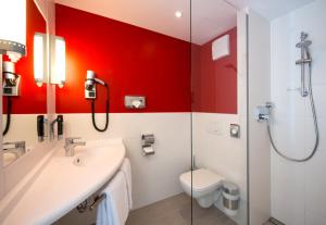 哈尔伯格摩斯慕尼黑机场南宜必思酒店的浴室配有卫生间、盥洗盆和淋浴。