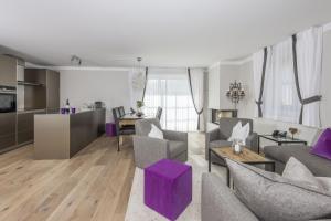 切勒里纳霍特力诺佩蒂特小木屋旅馆的一间带紫色家具的客厅和一间厨房