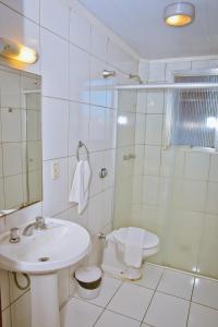 佩洛塔斯Hotel Estoril的白色的浴室设有水槽和淋浴。