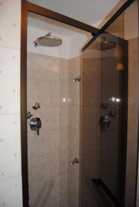 库马约尔德尔维亚雷酒店的浴室里设有玻璃门淋浴