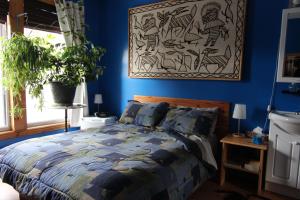 蒙特利尔伊特拉佩乌住宿加早餐旅馆的蓝色的卧室配有一张床,墙上挂着一幅画