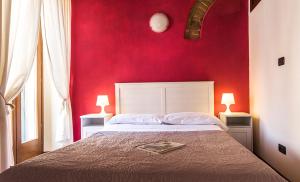 维罗纳维罗奈塔住宿加早餐旅馆的一间卧室配有一张红色墙壁的床