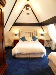 约克阿斯科特酒店的卧室配有白色大床和蓝色地毯