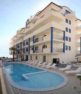 托尔托雷托Residence Abruzzo Resort的大楼前设有游泳池的酒店