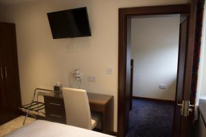 Beaumont博蒙特之家旅馆的酒店客房设有一张桌子和一台墙上的电视
