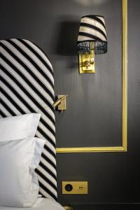 巴黎Snob Hotel的一间卧室配有一张带条纹床头板的床和镜子