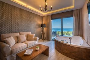 查加基恩Elegance Luxury Executive Suites - Adults Only的客厅设有大浴缸和沙发。