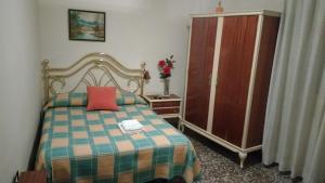 萨拉戈萨拉卡斯塔膳食酒店的一间卧室配有一张带红色枕头的床和橱柜