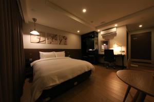首尔阔博斯酒店的一间卧室配有一张床、一张桌子和一把椅子