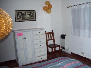 圣马丁德洛斯Casa Abedules de los Andes的一间卧室配有一张床、梳妆台和椅子