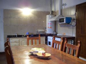 圣马丁德洛斯Casa Abedules de los Andes的厨房配有木桌、椅子和桌子。