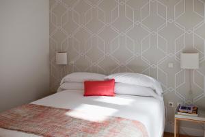 马德里60 Balconies Art的一间卧室配有一张红色枕头的床