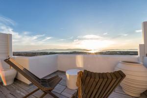 阿吉亚艾里尼帕罗Anna Platanou Suites的阳台配有两把椅子和一张桌子,享有日落美景。